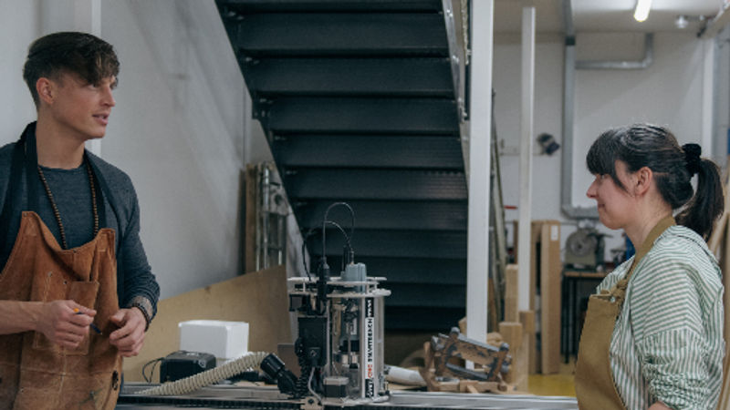 Two craftspeople discussing a project in the DaVinci workshop